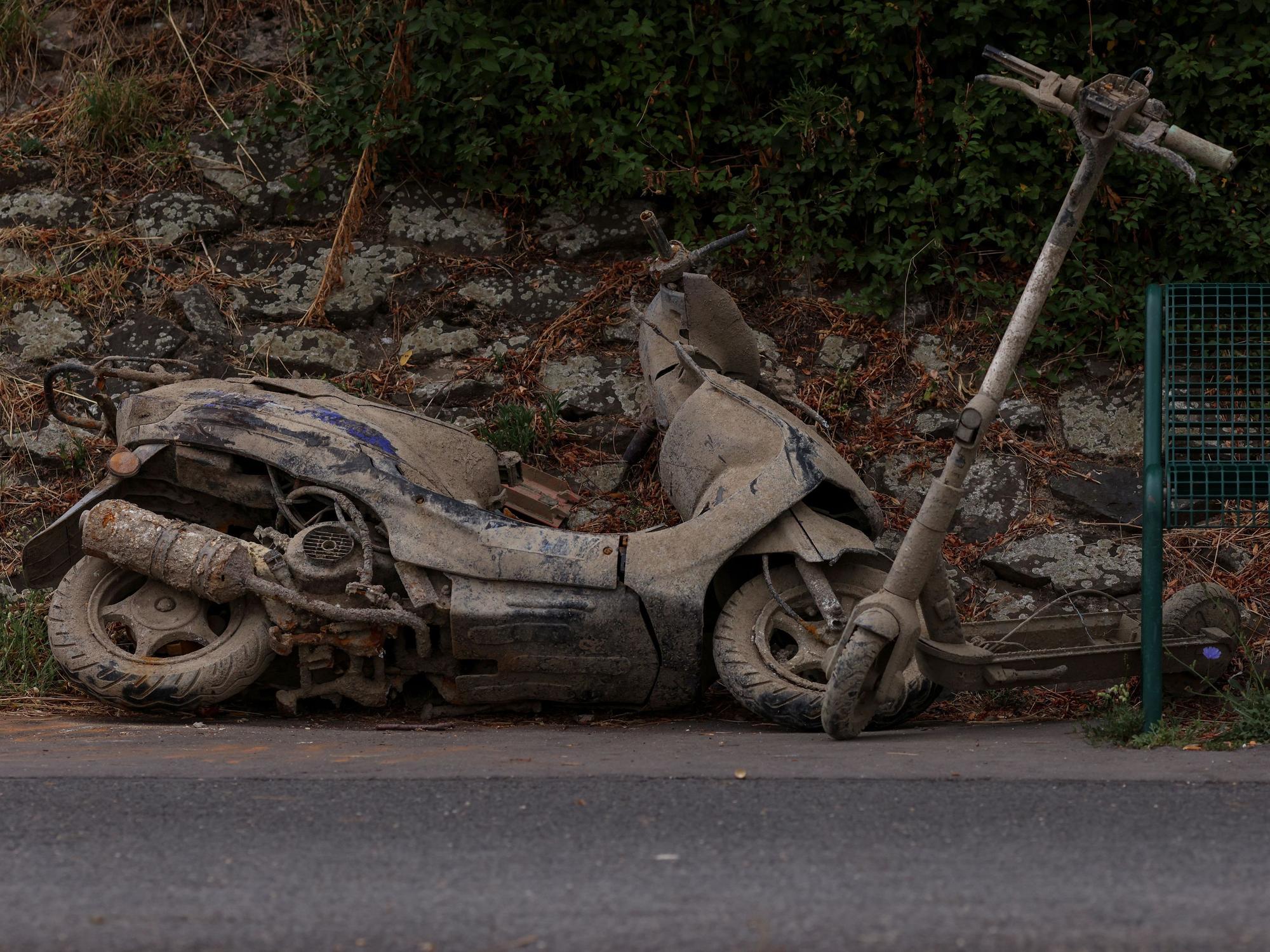 Ein Motorroller und ein E-Scooter liegen am Ufer in Köln-Stammheim.