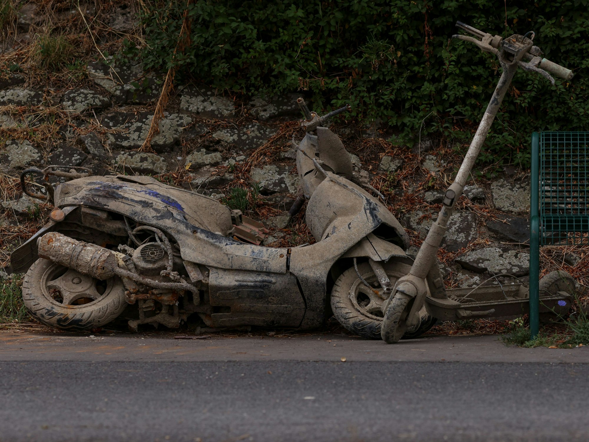 Ein Motorroller und ein E-Scooter liegen am Ufer in Köln-Stammheim.