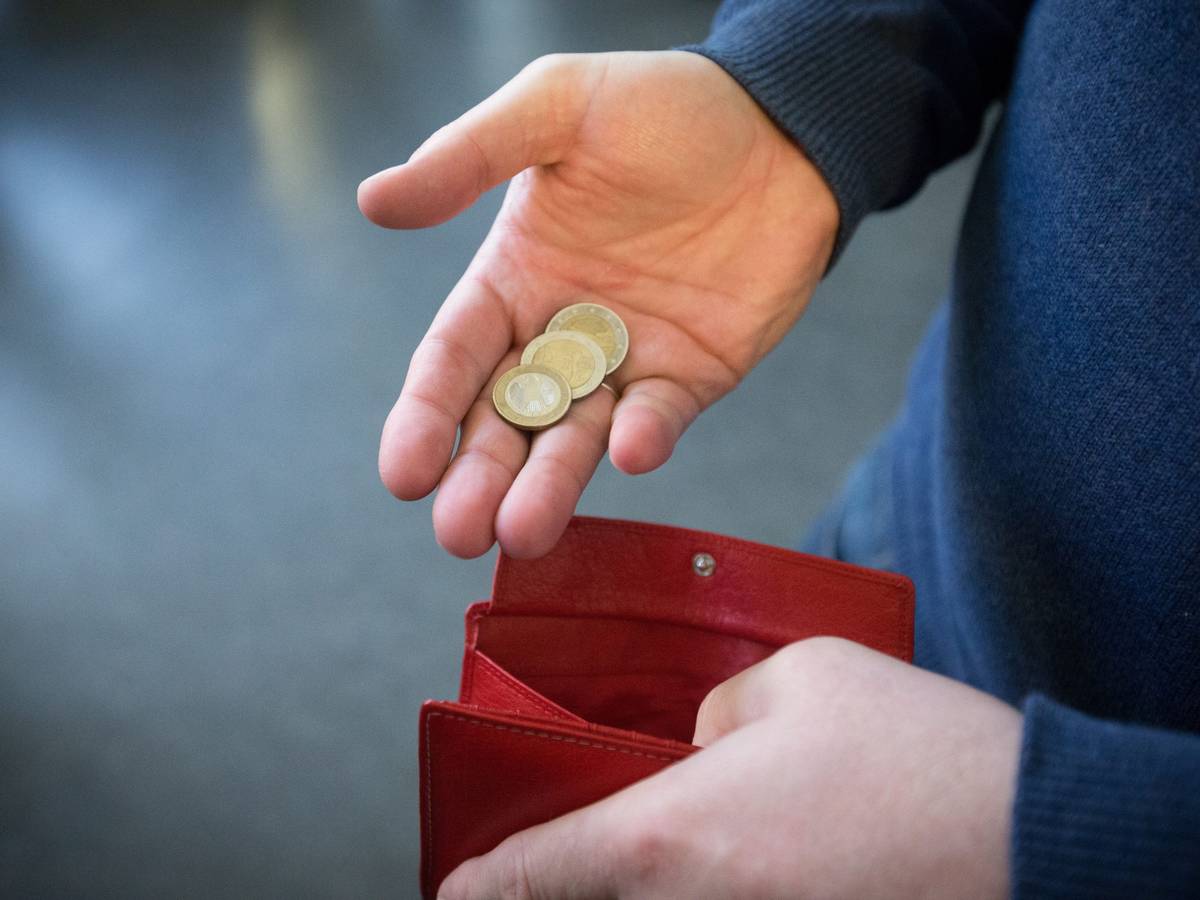 Münzen im Wert von fünf Euro werden auf diese undatierten Symbolbild über ein rotes Portemonnaie gehalten.