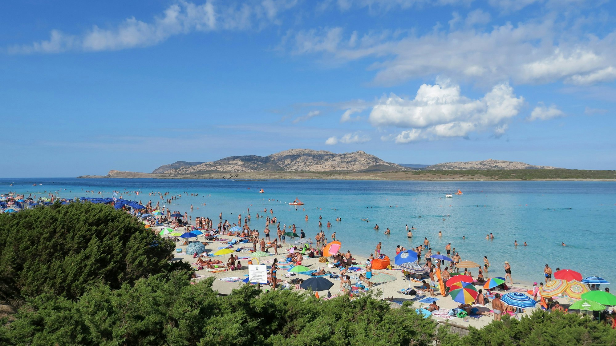 Badegäste am Strand auf der Mittelmeerinsel Sardinien