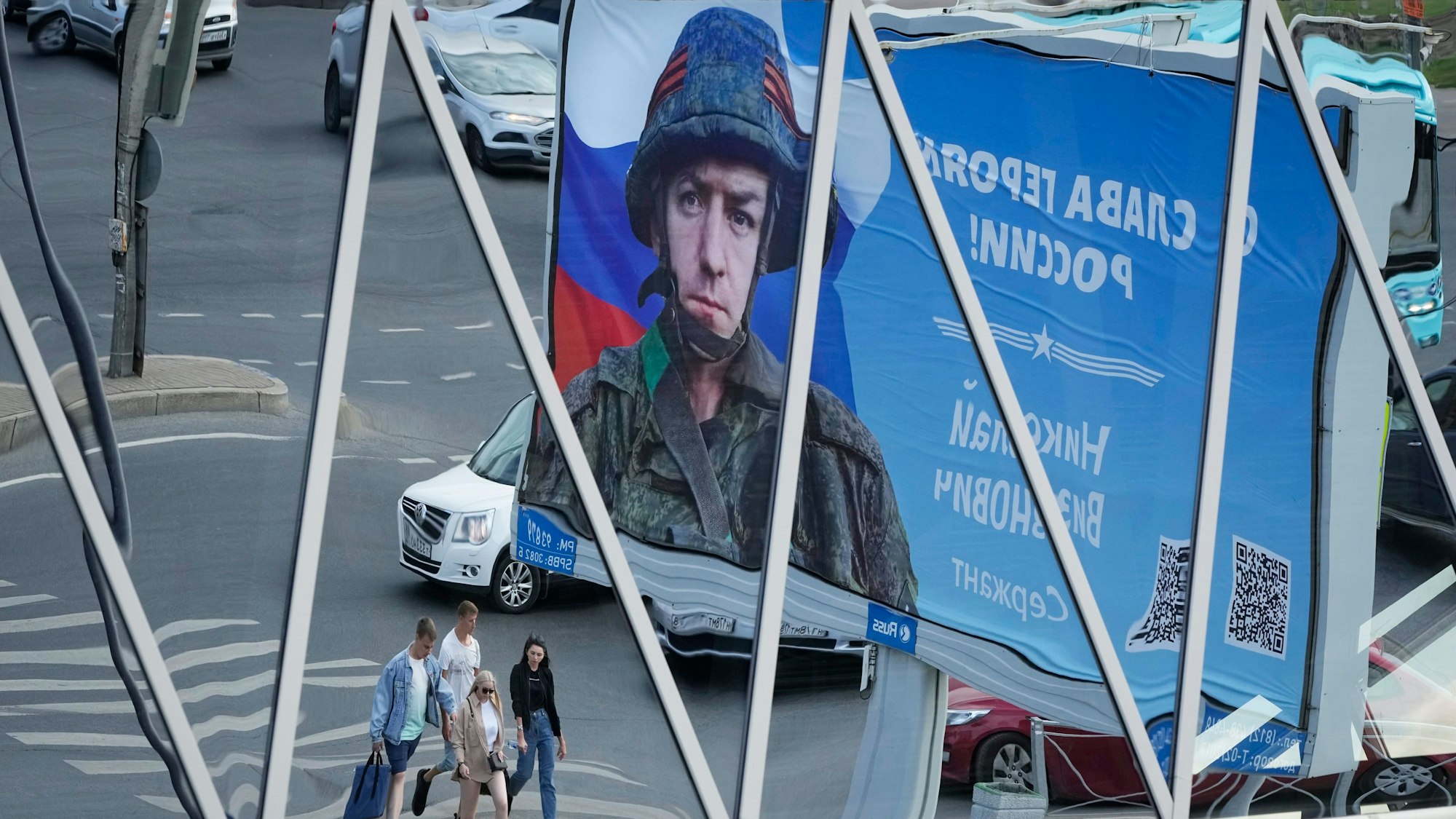 Ein Plakat mit dem Porträt eines russischen Soldaten und der Aufschrift „Ruhm für die Helden Russlands“ ist vor einem Einkaufszentrum in St. Petersburg zu sehen. Ein deutscher Journalist soll festgenommen worden sein, weil er eine regierungskritische Graffiti-Aktion gefilmt haben soll.