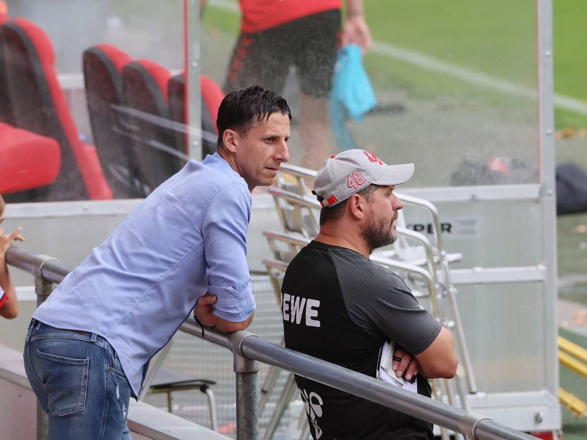FC-Sportchef Christian Keller (l.) lehnt sich hinter Trainer Steffen Baumgart ans Geländer am Geißbockheim.