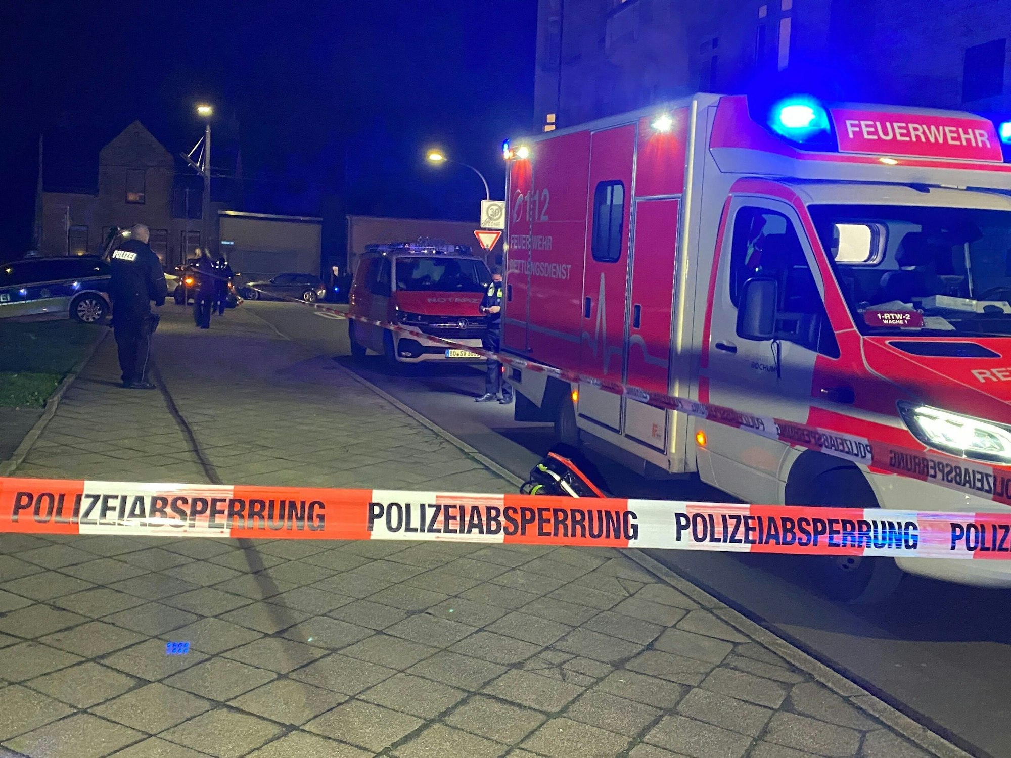 Polizei und Rettungswagen stehen an einem Gehsteig.