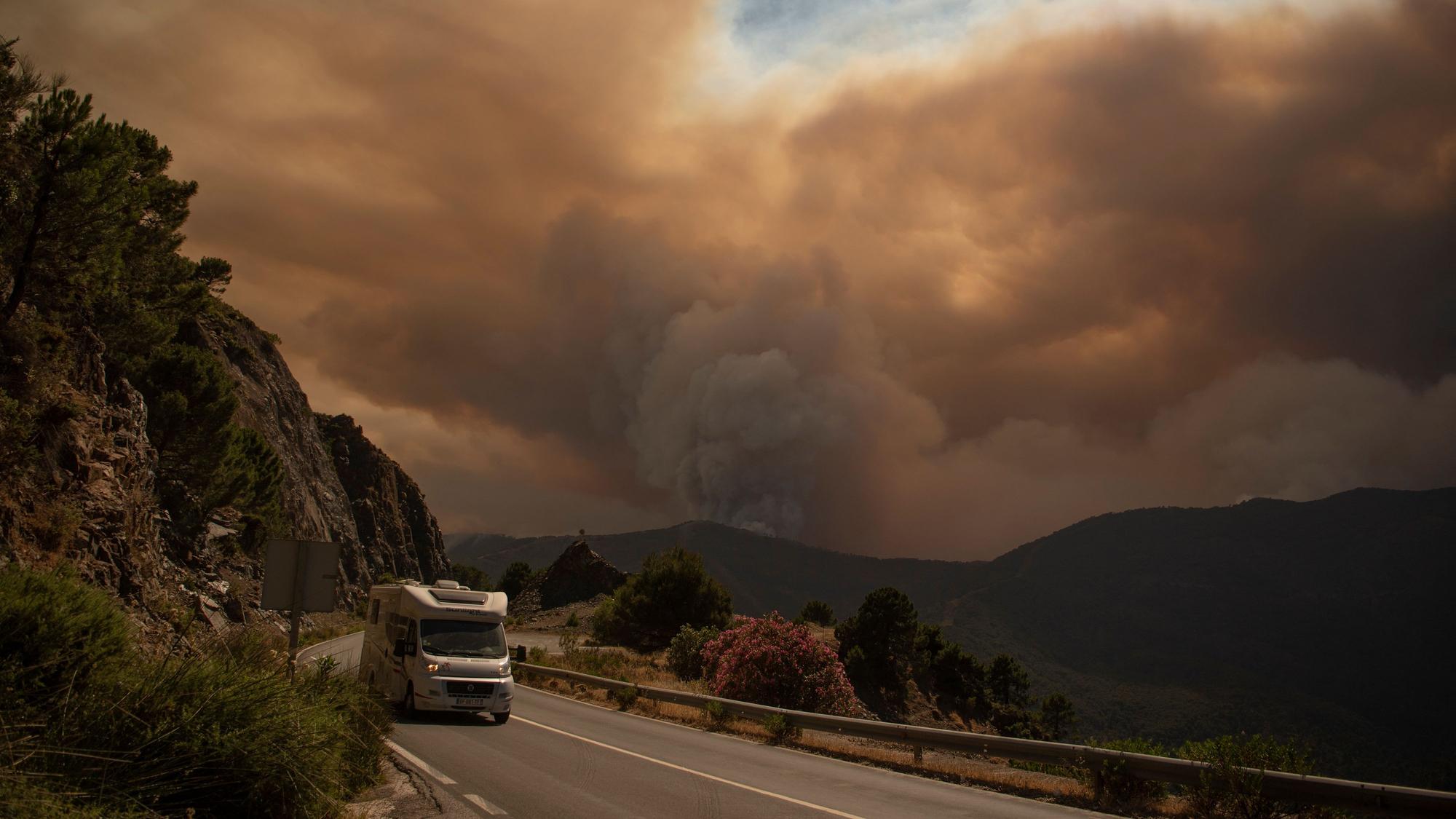 Ein Wohnmobil fährt aus dem Waldbrand-Gebiet der Sierra Bermeja heraus.