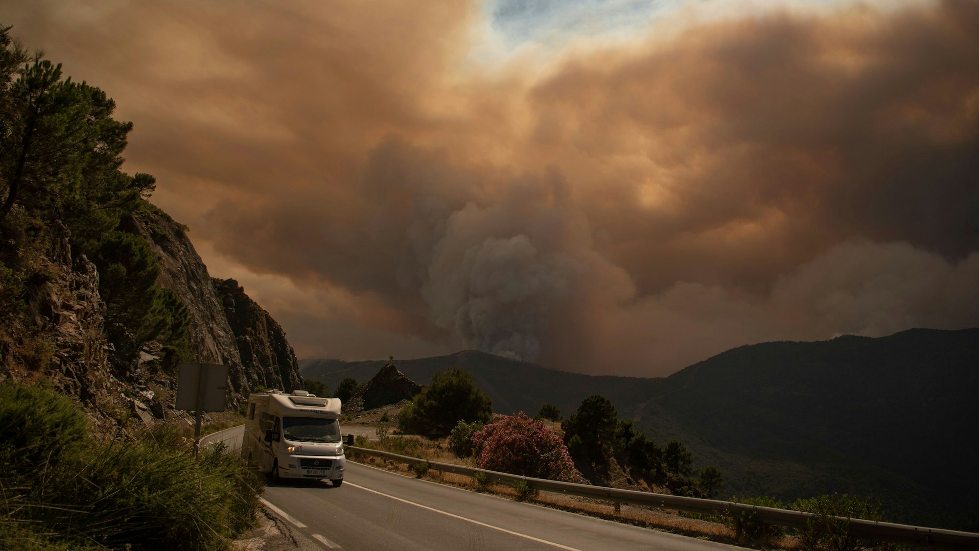 Ein Wohnmobil fährt aus dem Waldbrand-Gebiet der Sierra Bermeja heraus.