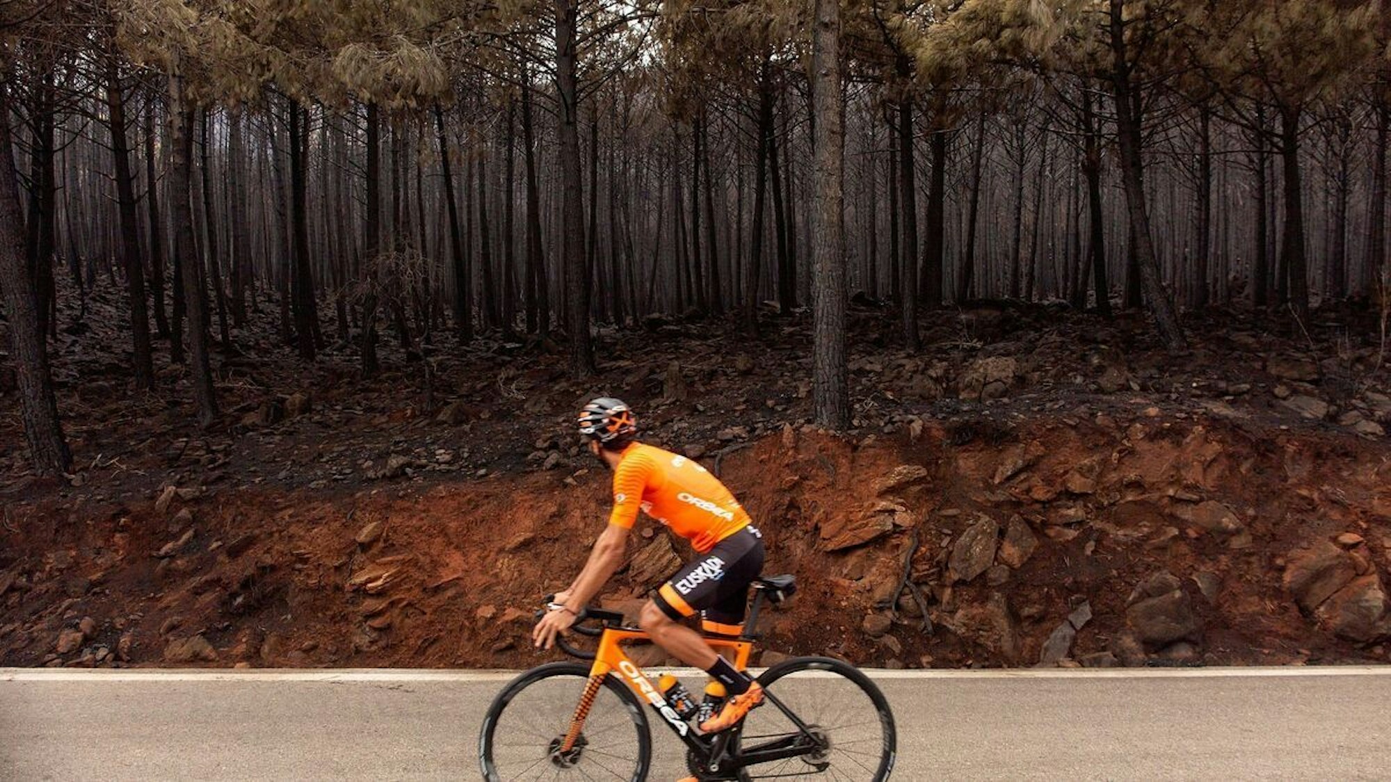 Radprofi Luis Ángel Maté bei einer Fahrt durch das Walbrand-Gebiet der Sierra Bermeja.