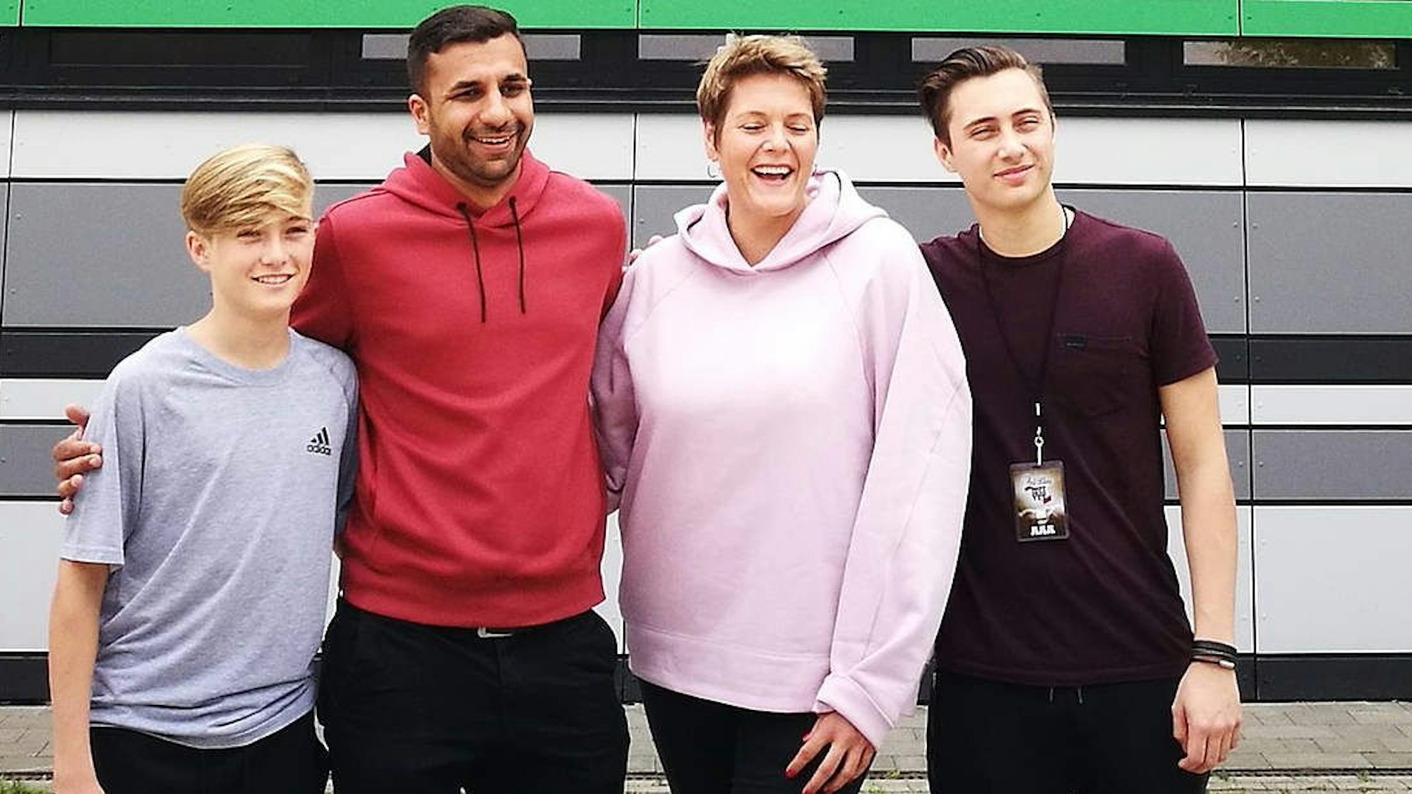 Mathew Collins posiert auf einem Foto mit mehreren Leuten, darunter Bruder Nicholas, im Nachwuchsleistungszentrum von Hannover 96.