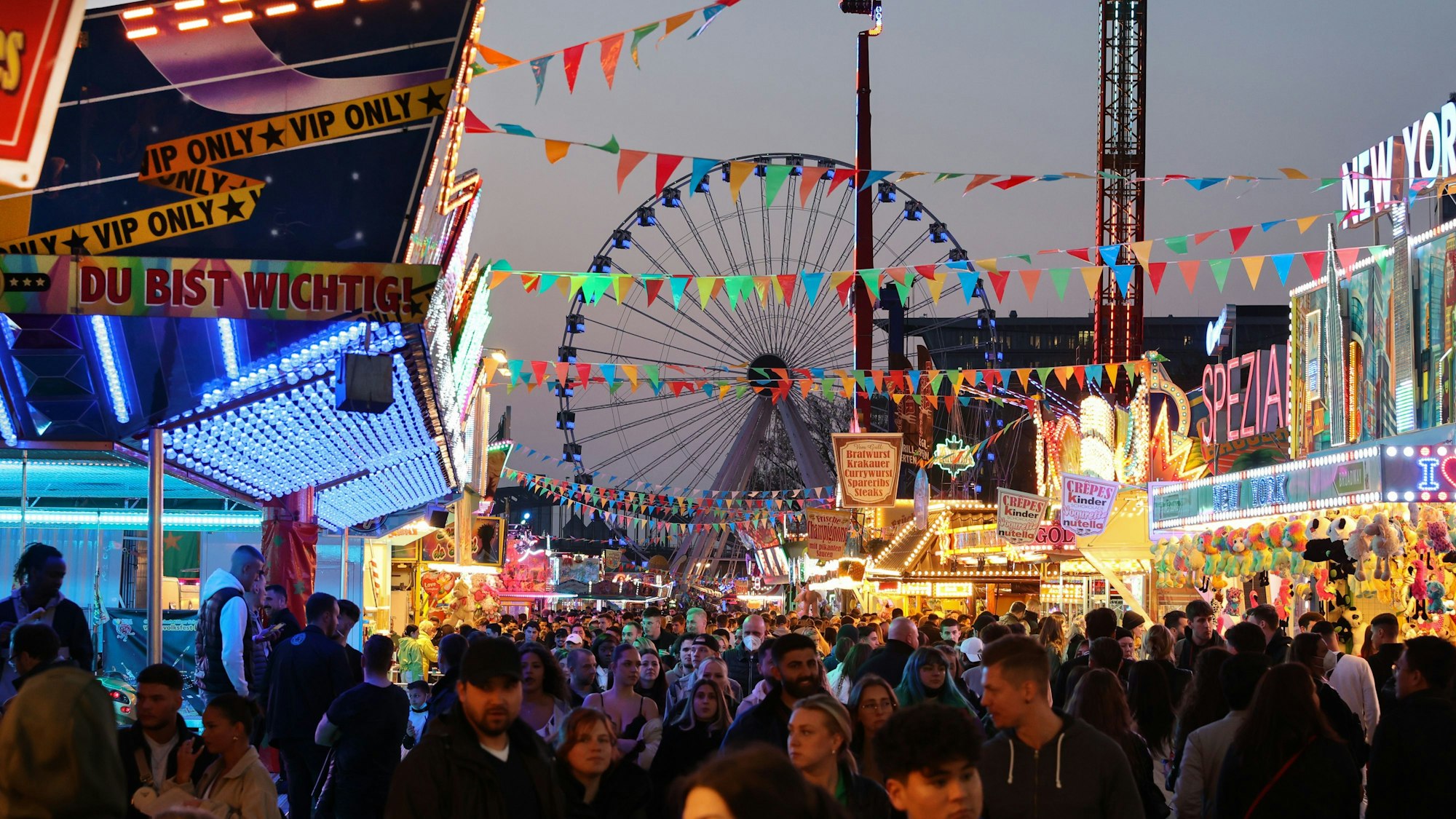 Menschen auf der Rheinkirmes in Köln-Deutz am späten Abend.