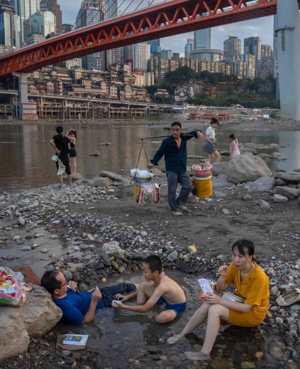 Chongqing: Menschen sitzen in einem flachen Wasserbecken im Flussbett des Jialing-Flusses, eines Nebenflusses des Jangtse, in der südwestchinesischen Stadt Chongqing.