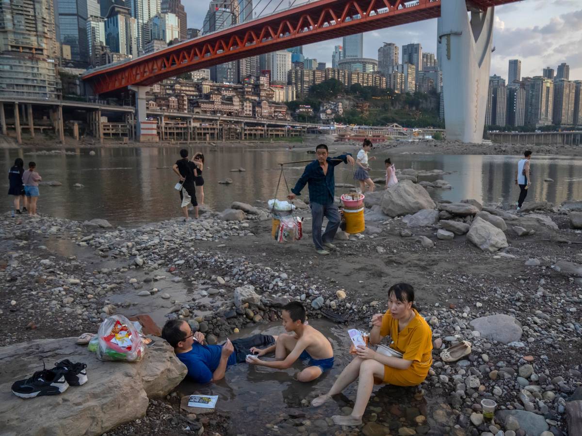 Chongqing: Menschen sitzen in einem flachen Wasserbecken im Flussbett des Jialing-Flusses, eines Nebenflusses des Jangtse, in der südwestchinesischen Stadt Chongqing.