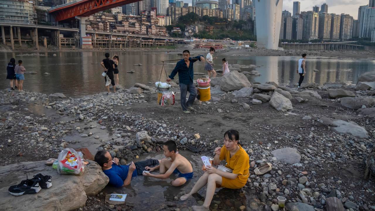 Chongqing: Menschen sitzen in einem flachen Wasserbecken im Flussbett des Jialing-Flusses, eines Nebenflusses des Jangtse, in der südwestchinesischen Stadt Chongqing.