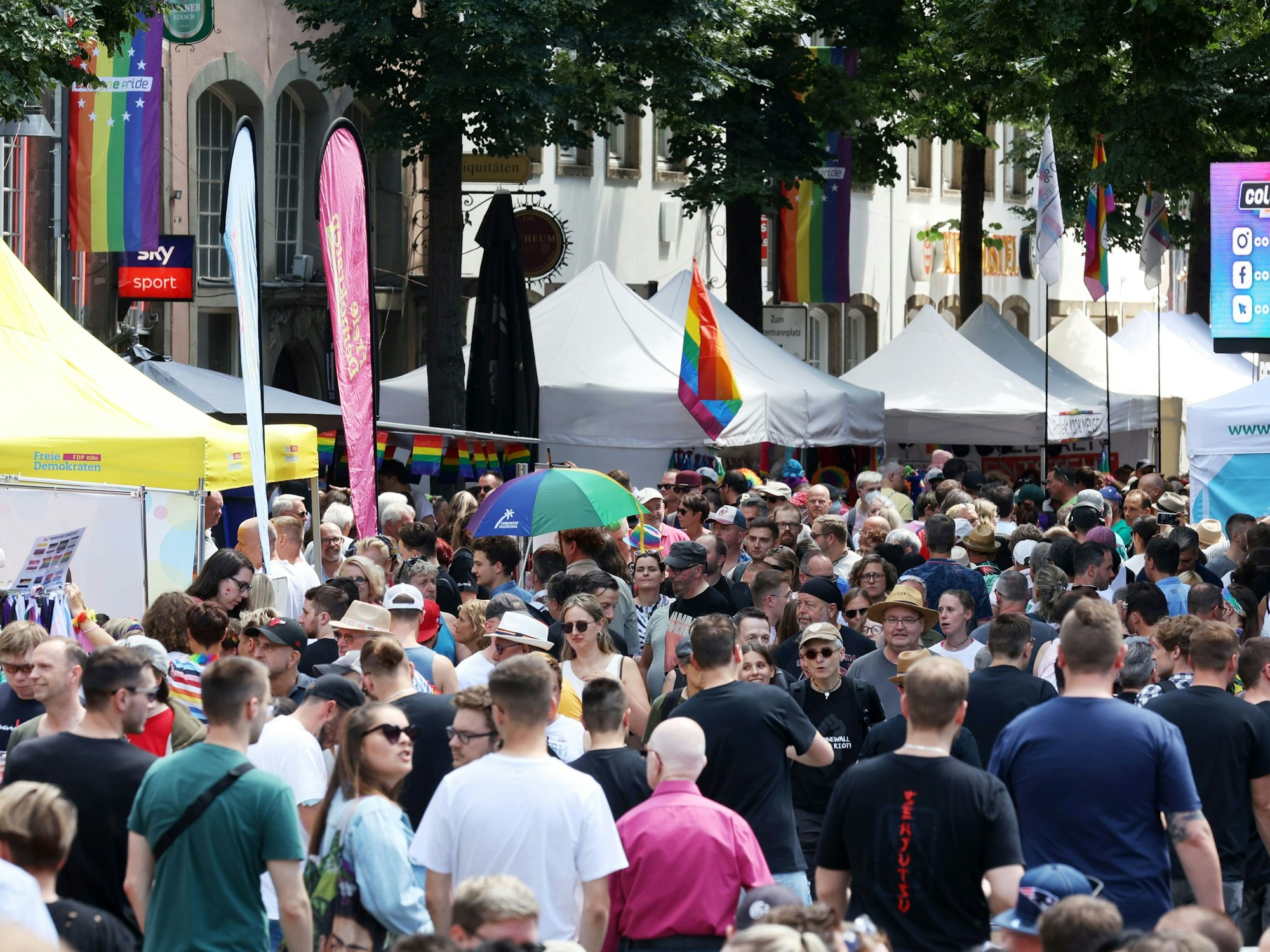 Viele Menschen laufen während des CSDs über das Straßenfest.
