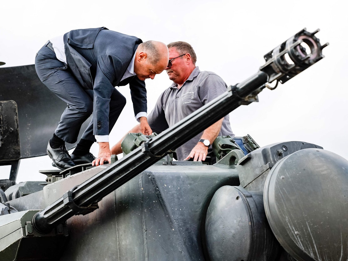 Bundeskanzler Olaf Scholz (l.) klettert mit dem Ausbildungsleiter des Waffenherstellers Krauss-Maffei Jürgen Schoch auf einen deutschen Flakpanzer Gepard