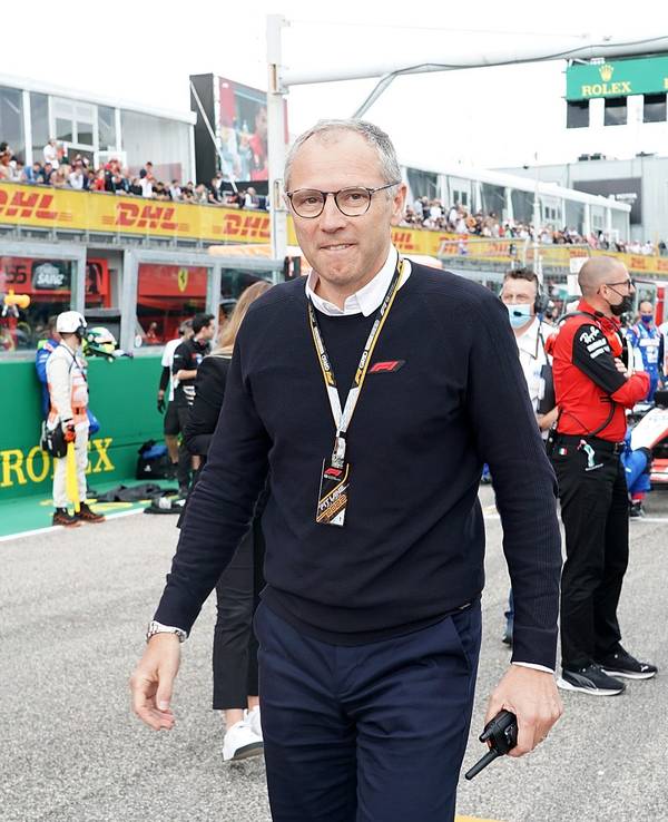 Formel 1 Chef Stefano Domenicali leicht grinsend in der Startaufstellung.