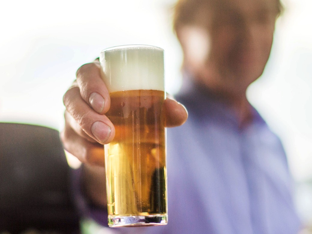 Ein frisch gezapftes Kölsch wird auf einer Party in die Kamera gehalten. Bier wird voraussichtlich schon bald deutlich teurer.