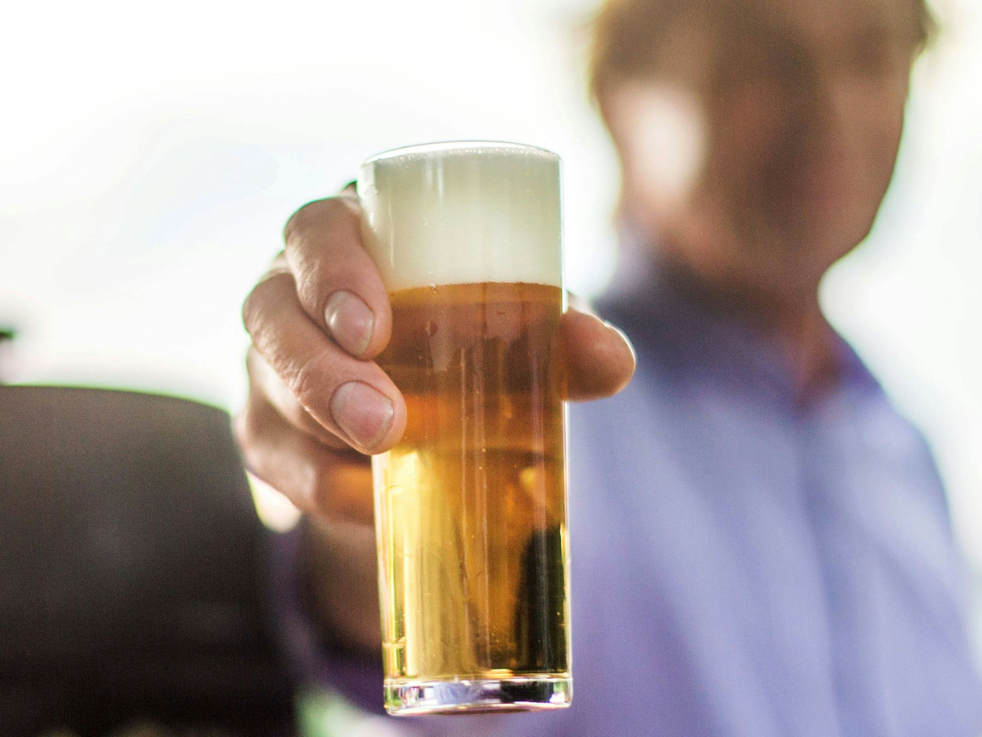 Ein frisch gezapftes Kölsch wird auf einer Party in die Kamera gehalten. Bier wird voraussichtlich schon bald deutlich teurer.