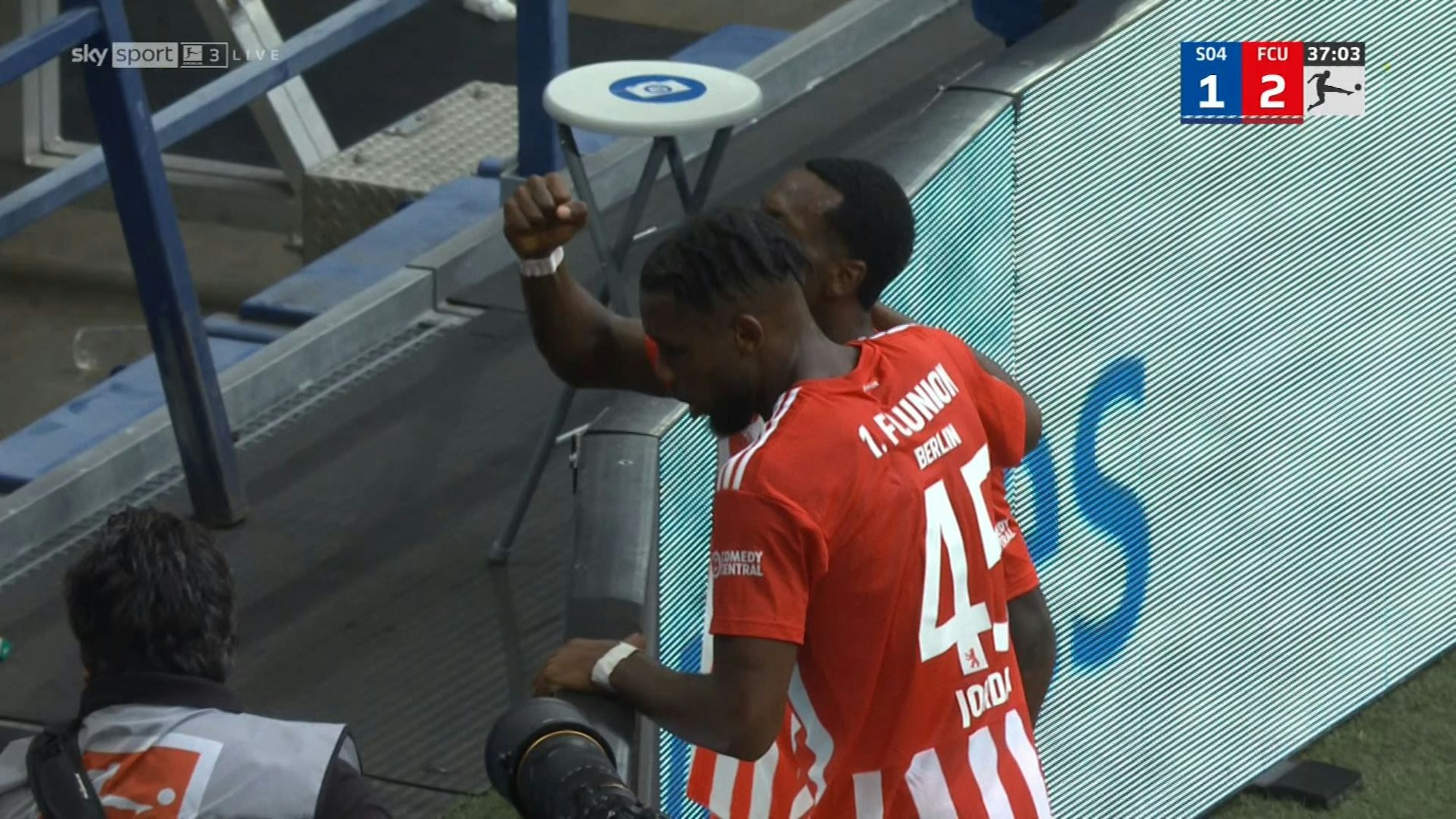 Beim Spiel des FC Schalke gegen Union Berlin in der Bundesliga kommt es beim Torjubel von Union Berlin vor der Gäste-Kurve zu einem medizinischen Notfall. Die Spieler der Gäste blicken besorgt nach unten.