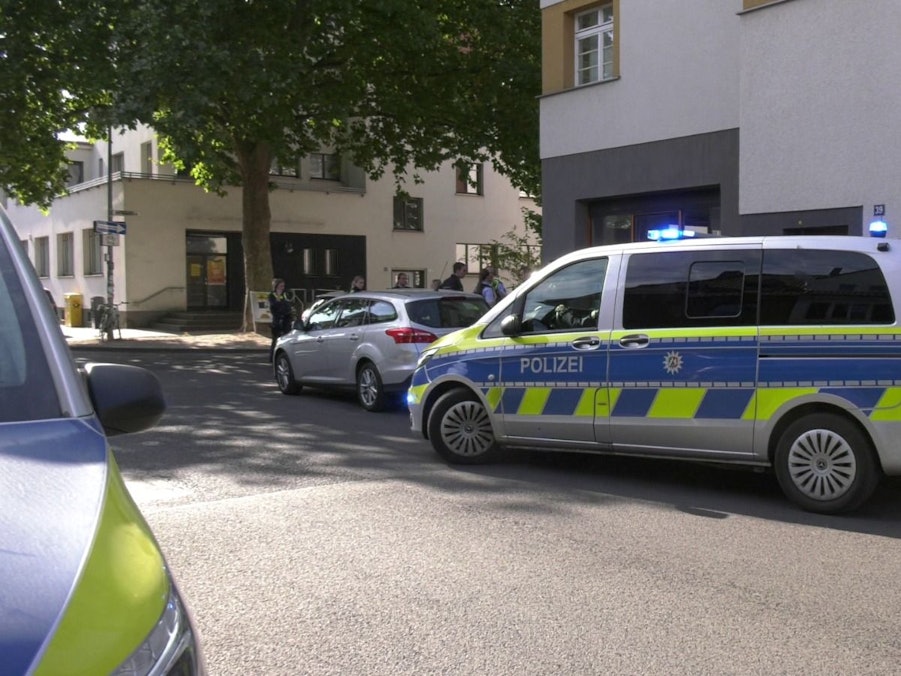 Zwei Polizeifahrzeuge parken in einer Straße.