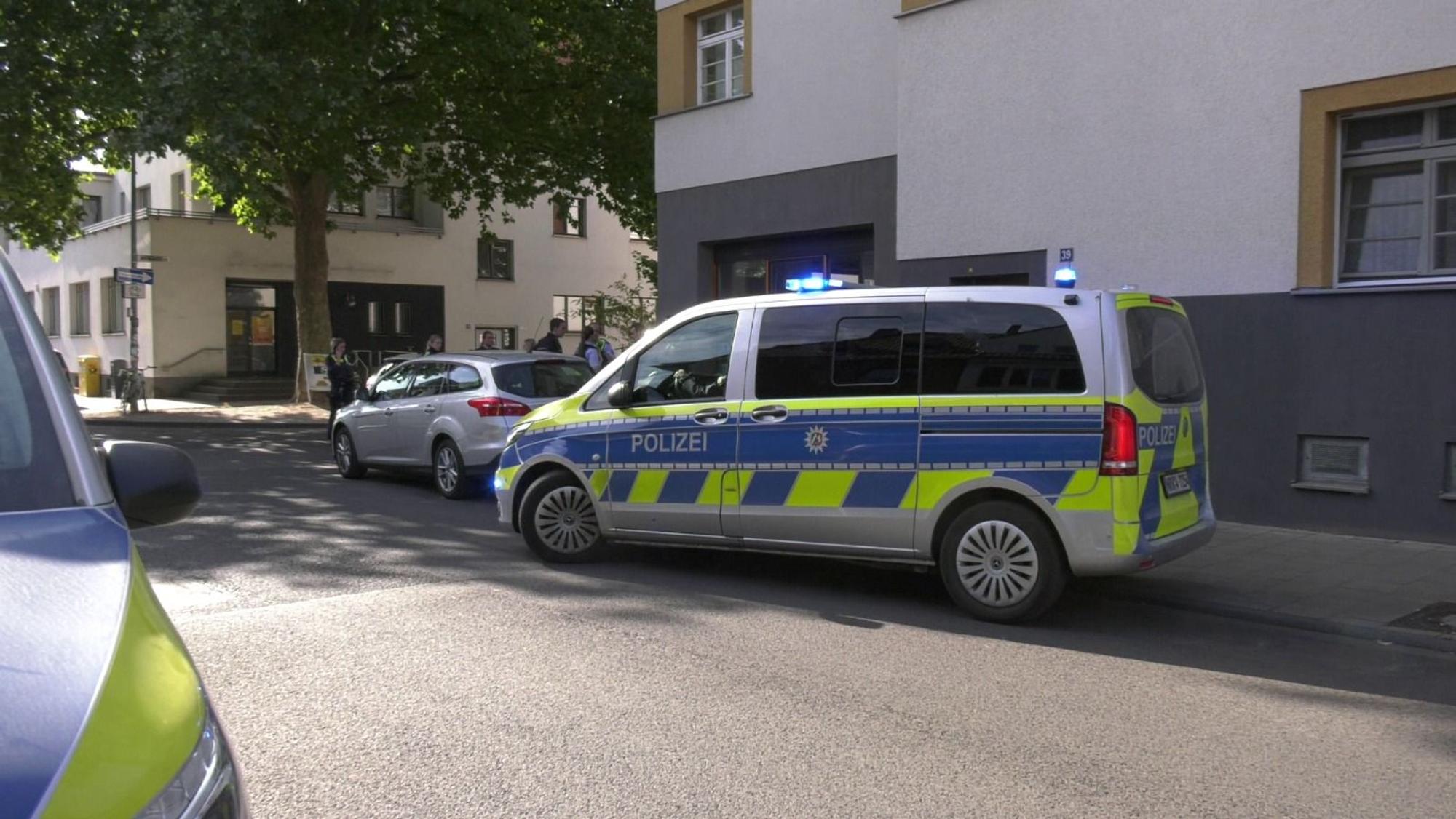 Zwei Polizeifahrzeuge parken in einer Straße.