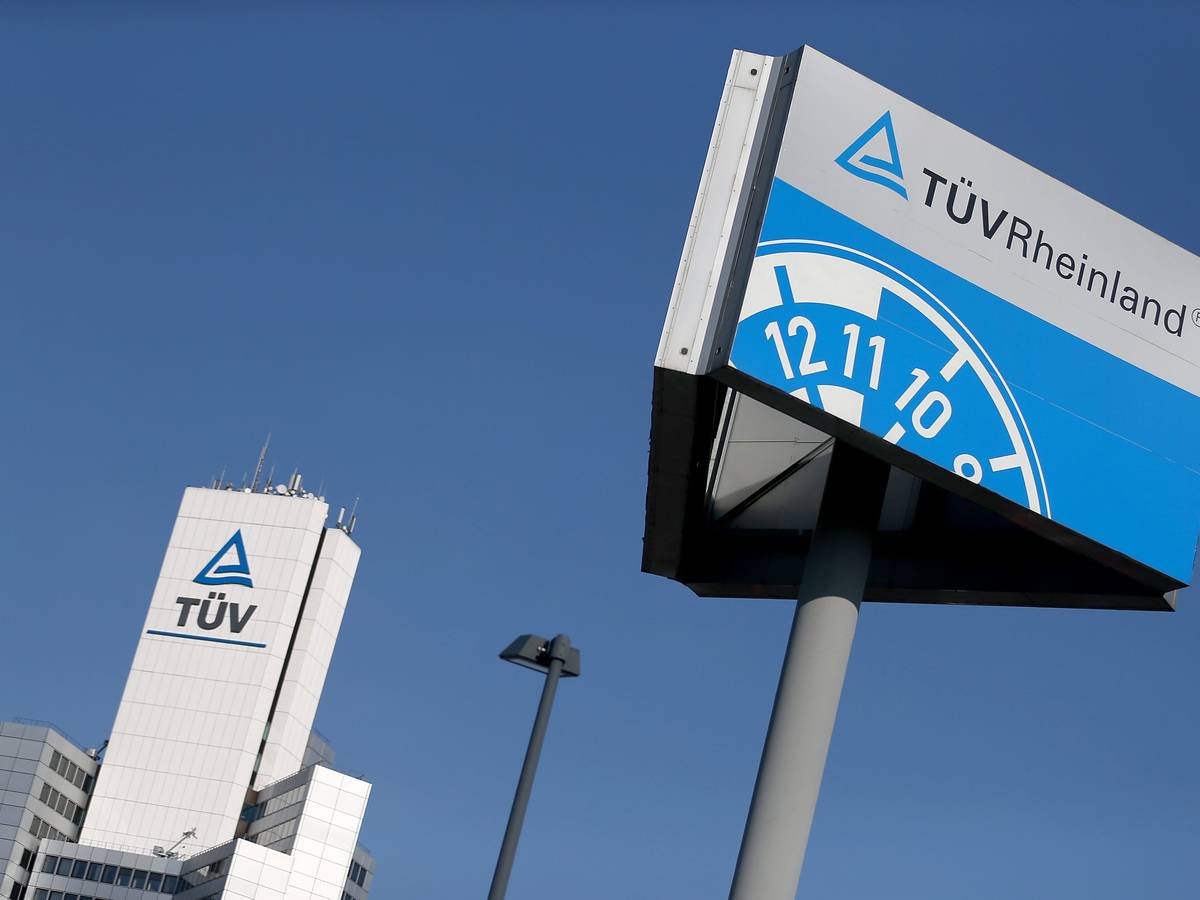 Ein Hinweisschild einer Kfz-Prüfstelle des TÜV Rheinland steht neben der Unternehmenszentrale.