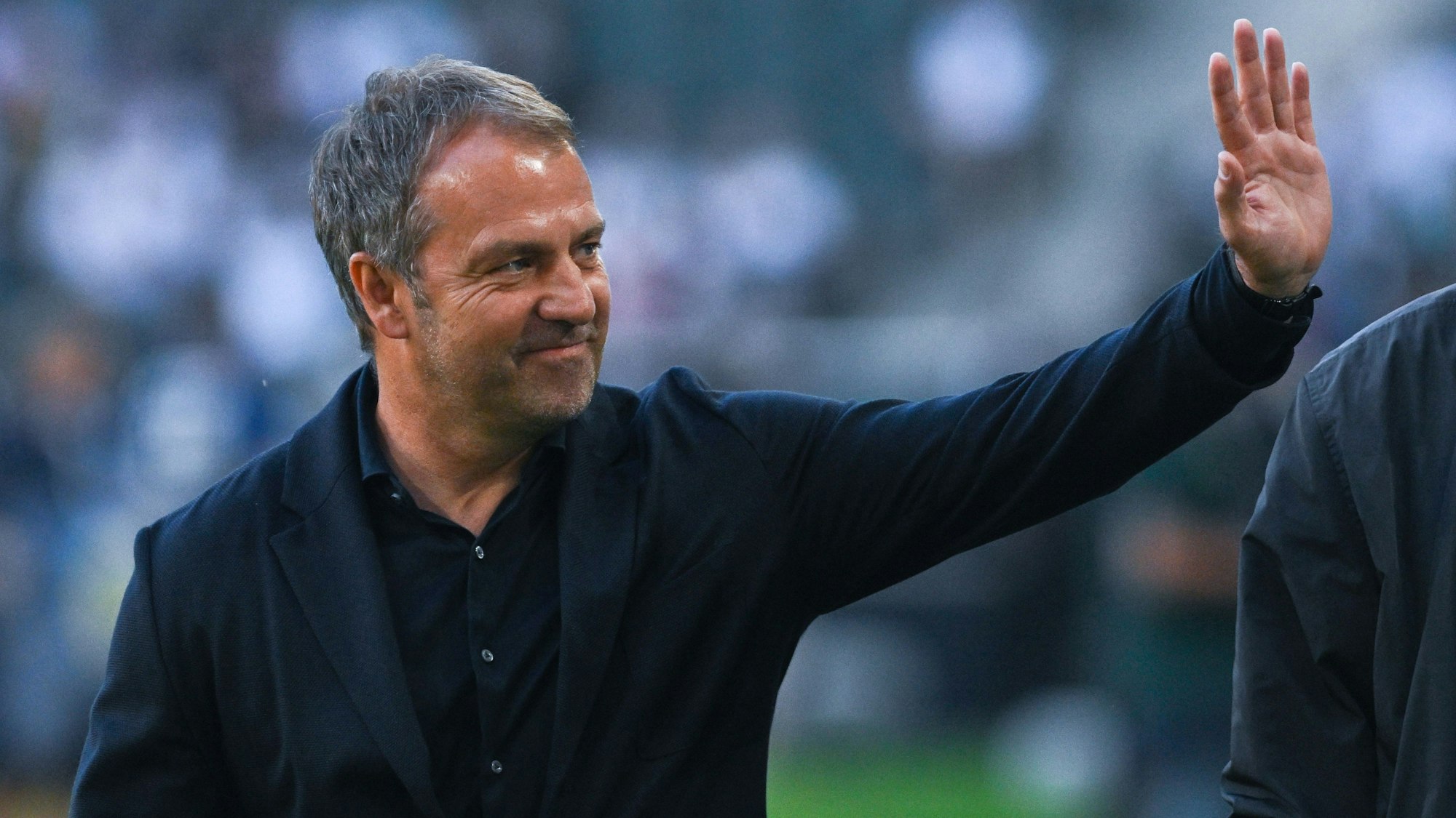 Hansi Flick winkt bei einem Deutschland-Spiel auf die Tribüne.