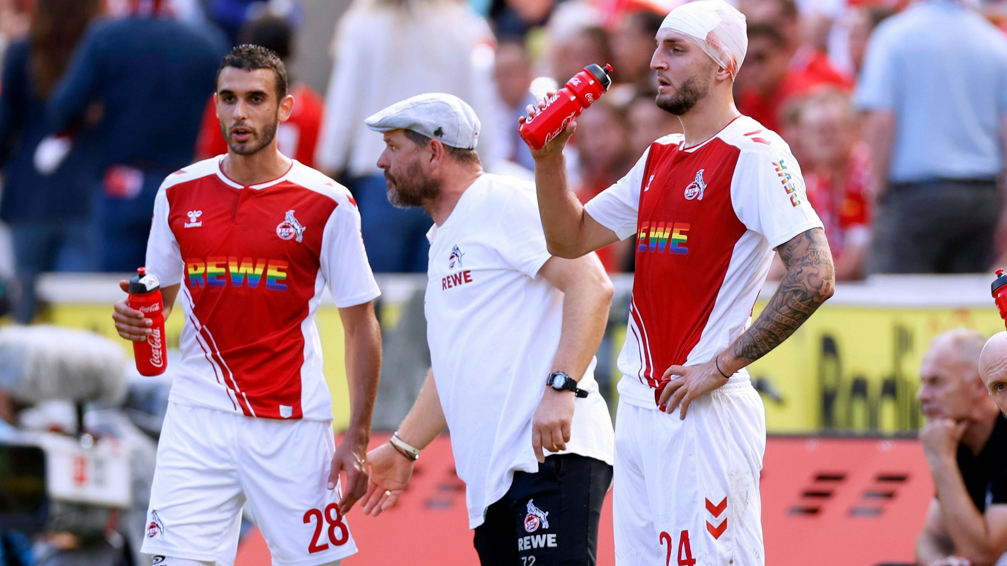 Jeff Chabot (r.), und Ellyes Skhiri (l.) stehen am Spielfeldrand neben FC-Trainer Steffen Baumgart.