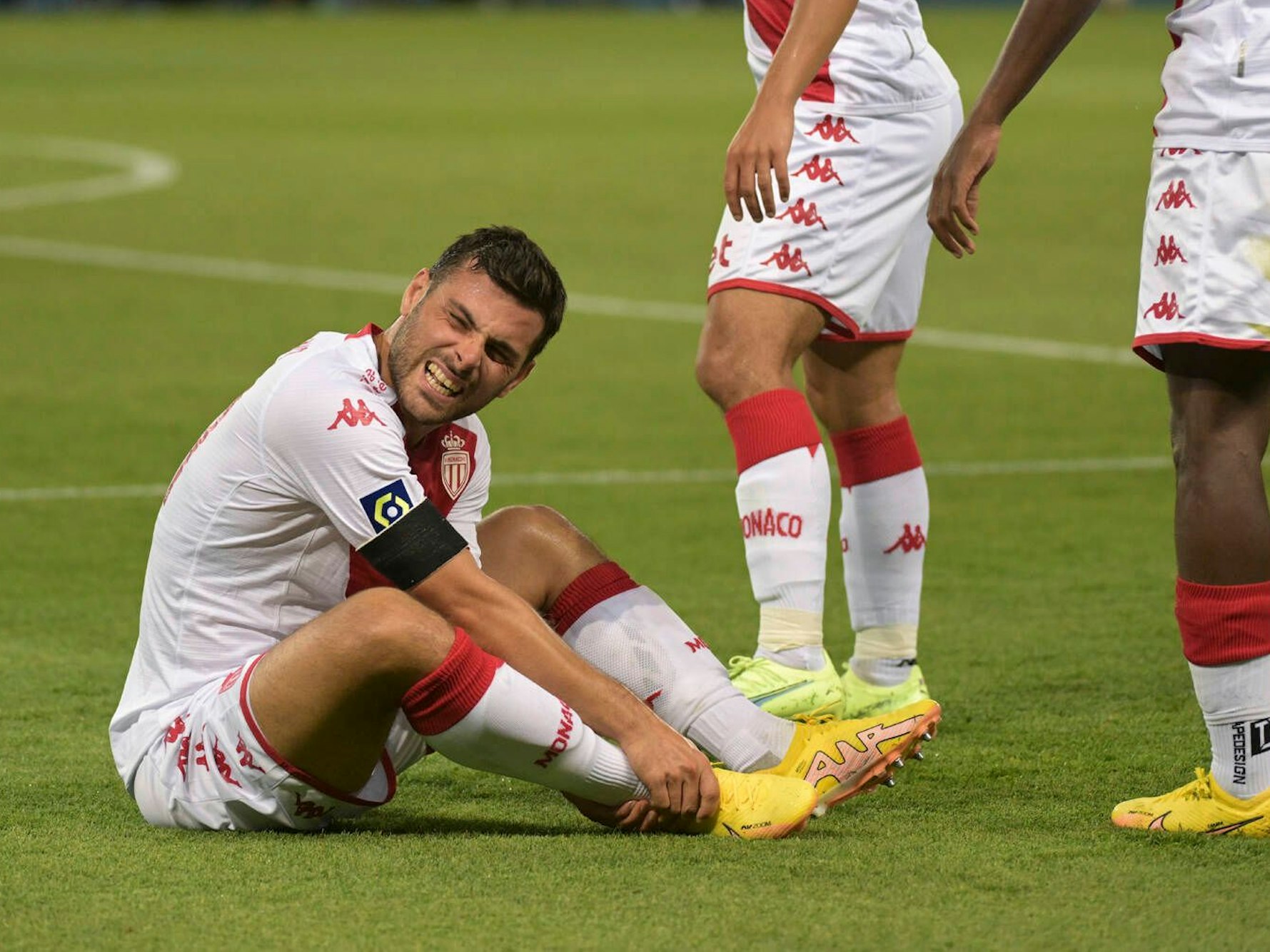 Kevin Volland hält mit schmerzverzerrtem Gesicht seinen Knöchel.
