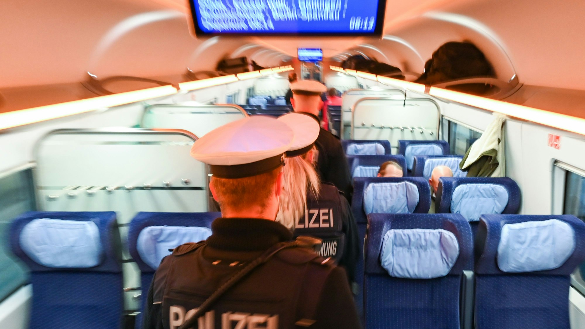 Polizeibeamte und -beamtinnen gehen durch einen ICE. Die Aufnahme dient als Symbolfoto.
