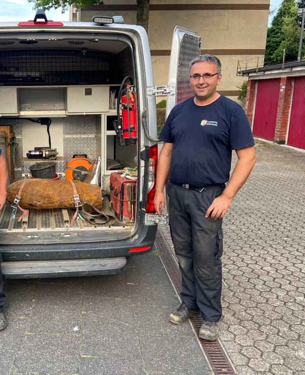 Zwei Männer stehen neben einer entschärften Weltkriegsbombe.