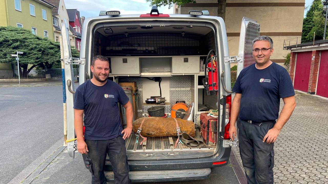 Zwei Männer stehen neben einer entschärften Weltkriegsbombe.
