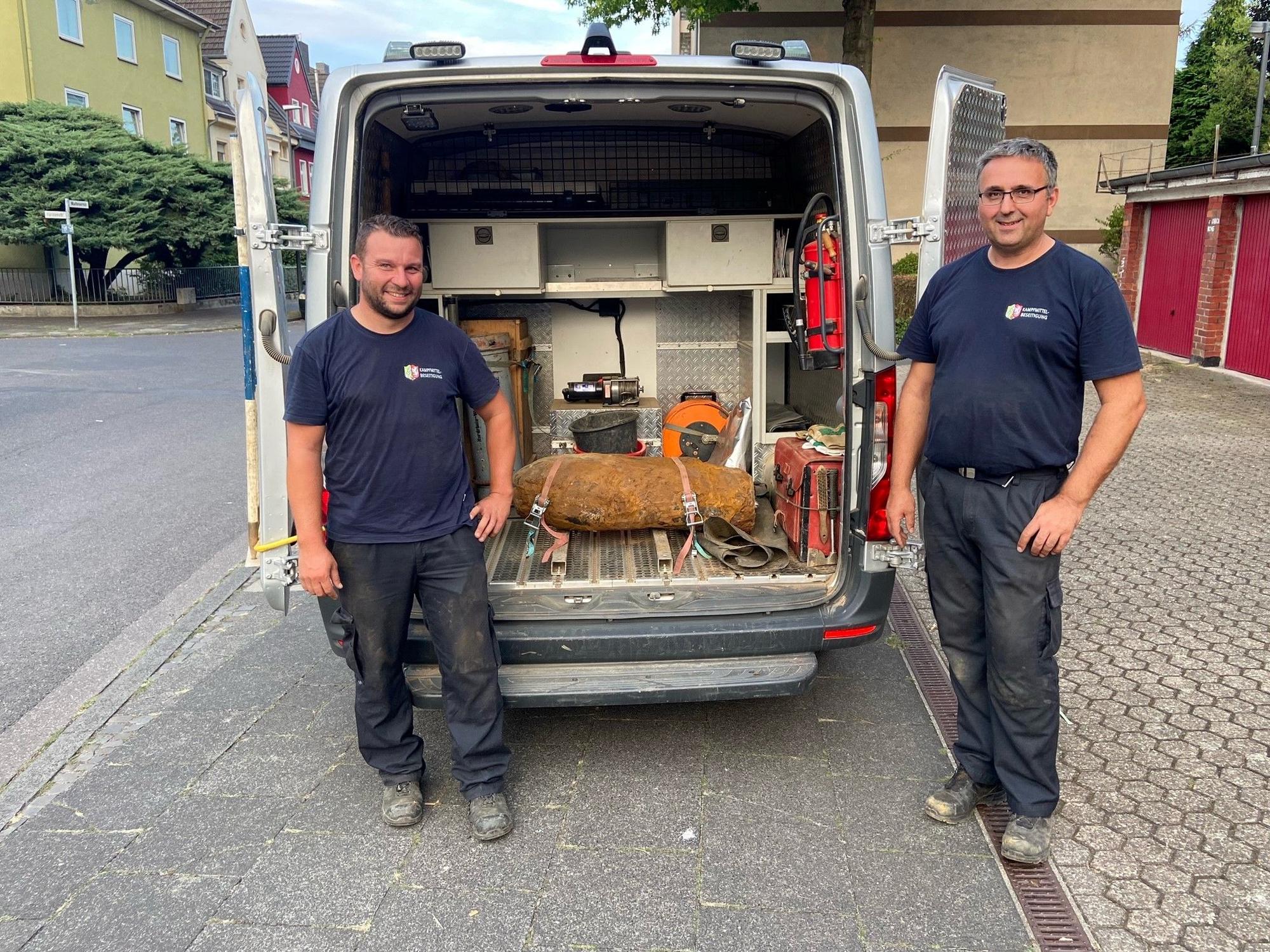 Zwei Männer stehen neben einer entschärften Weltkriegsbombe.