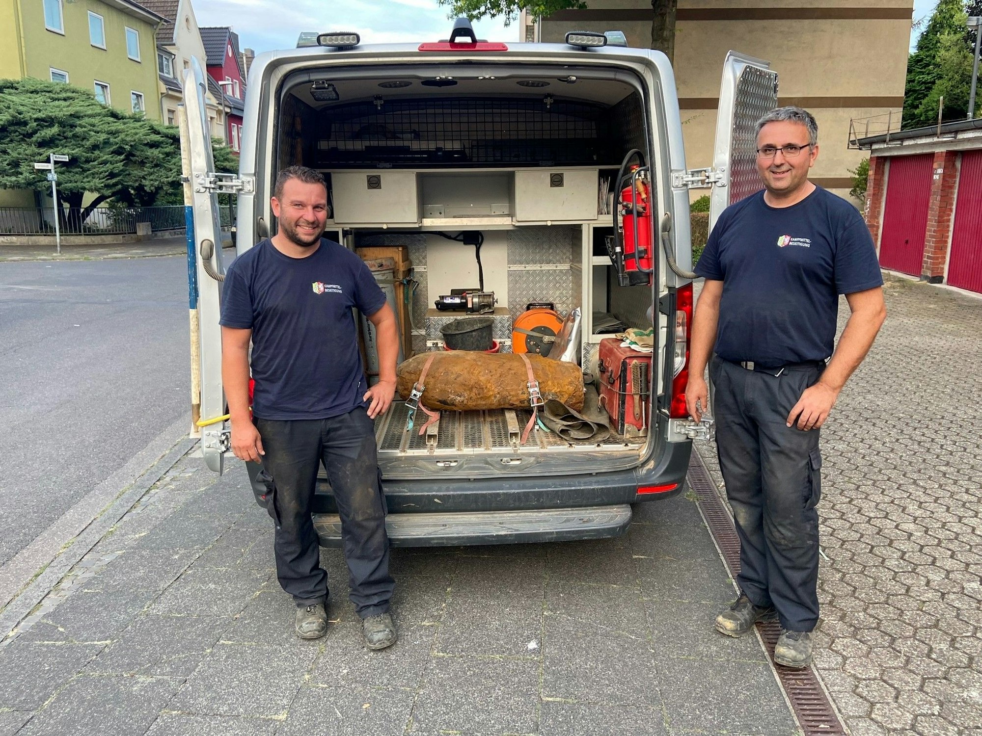 Zwei Männer stehen neben einer entschärften Weltkriegsbombe.