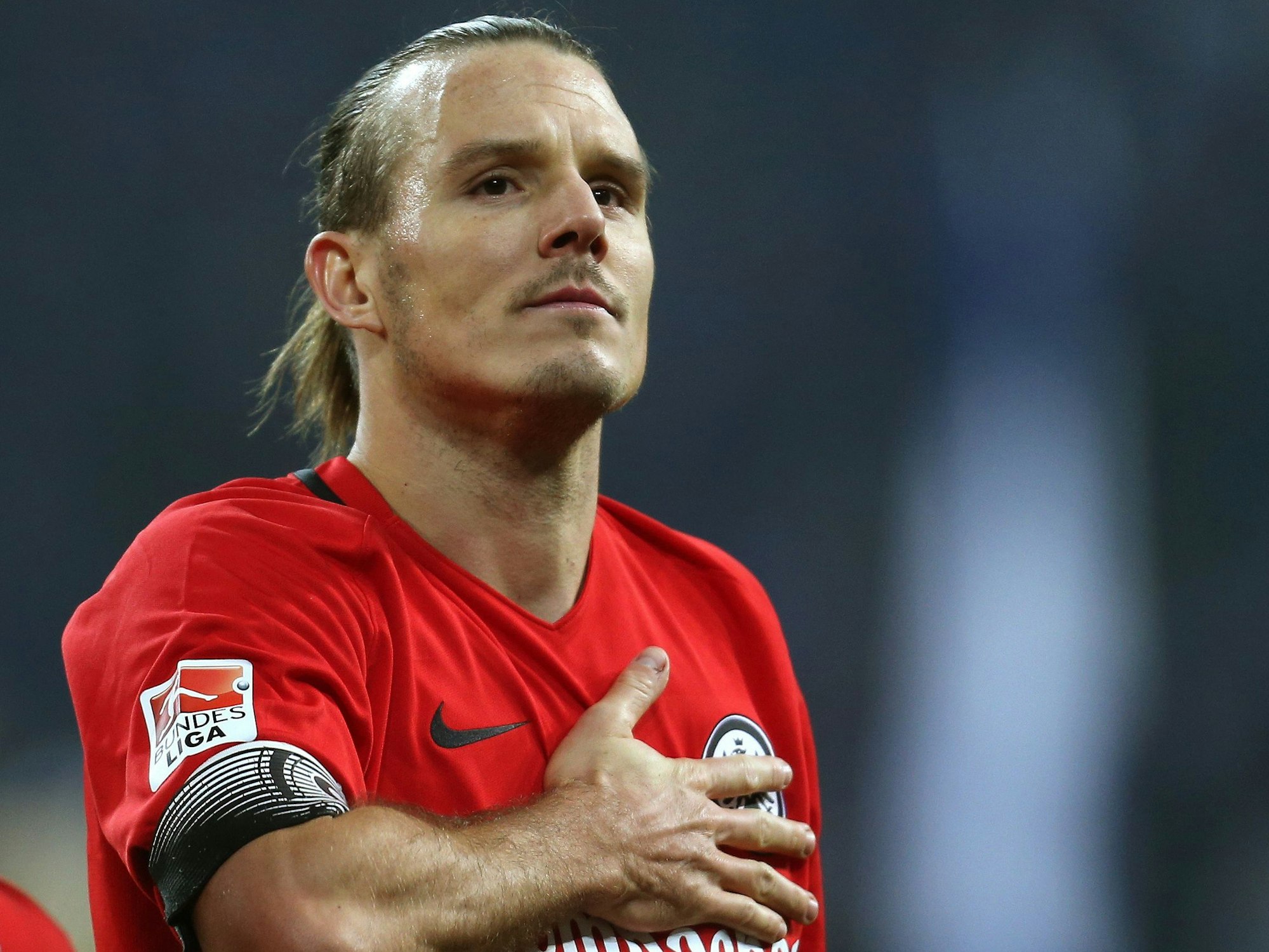 Alexander Meier von Frankfurt bejubelt den 1:0-Sieg gegen Schalke, indem er sich an das Eintracht-Wappen auf seiner Brust fasst.