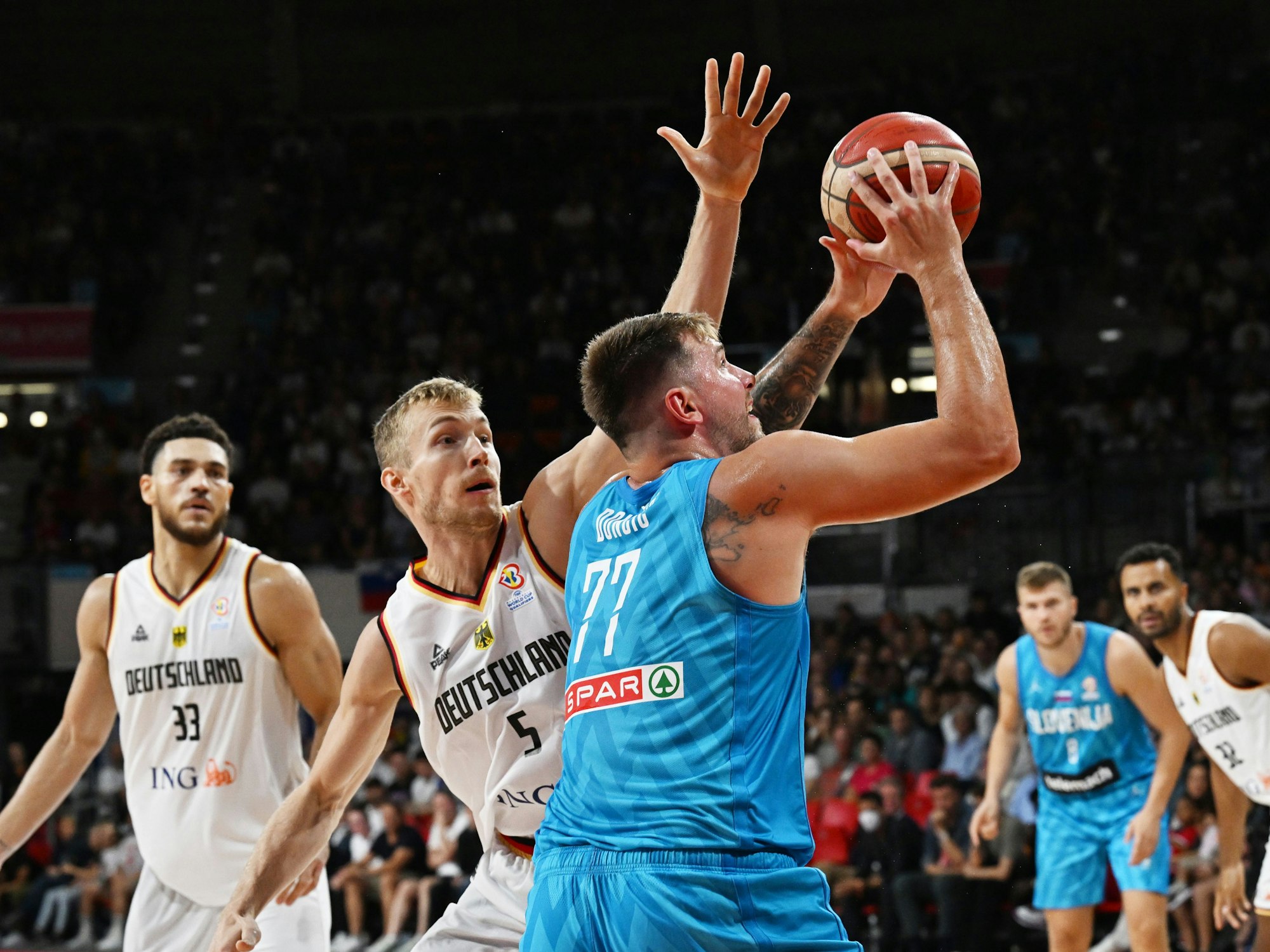 Deutschlands Gavin Schilling und Niels Giffey spielen gegen Sloweniens Luka Doncic den Ball.