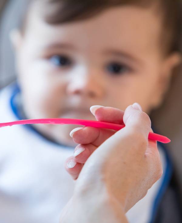 Das Foto von August 2019 zeigt eine Mutter, die ihr Kleinkind mit Babybrei füttert. Es handelt sich bei der Aufnahme um ein Symbolfoto.