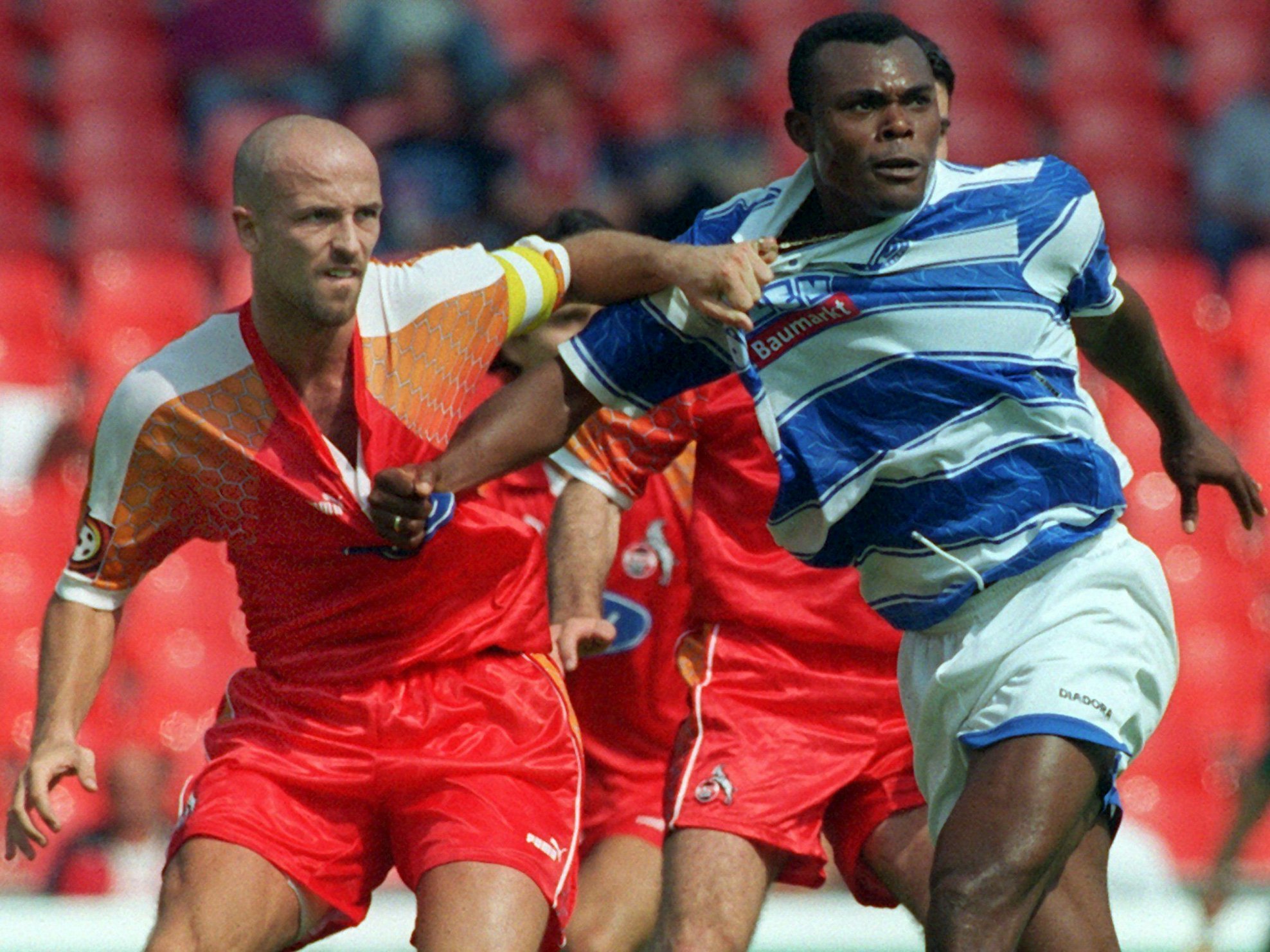 Karsten Baumann vom 1. FC Köln (l.) im Zweikampf mit Duisburgs Bachirou Salou am 2. August 1997.