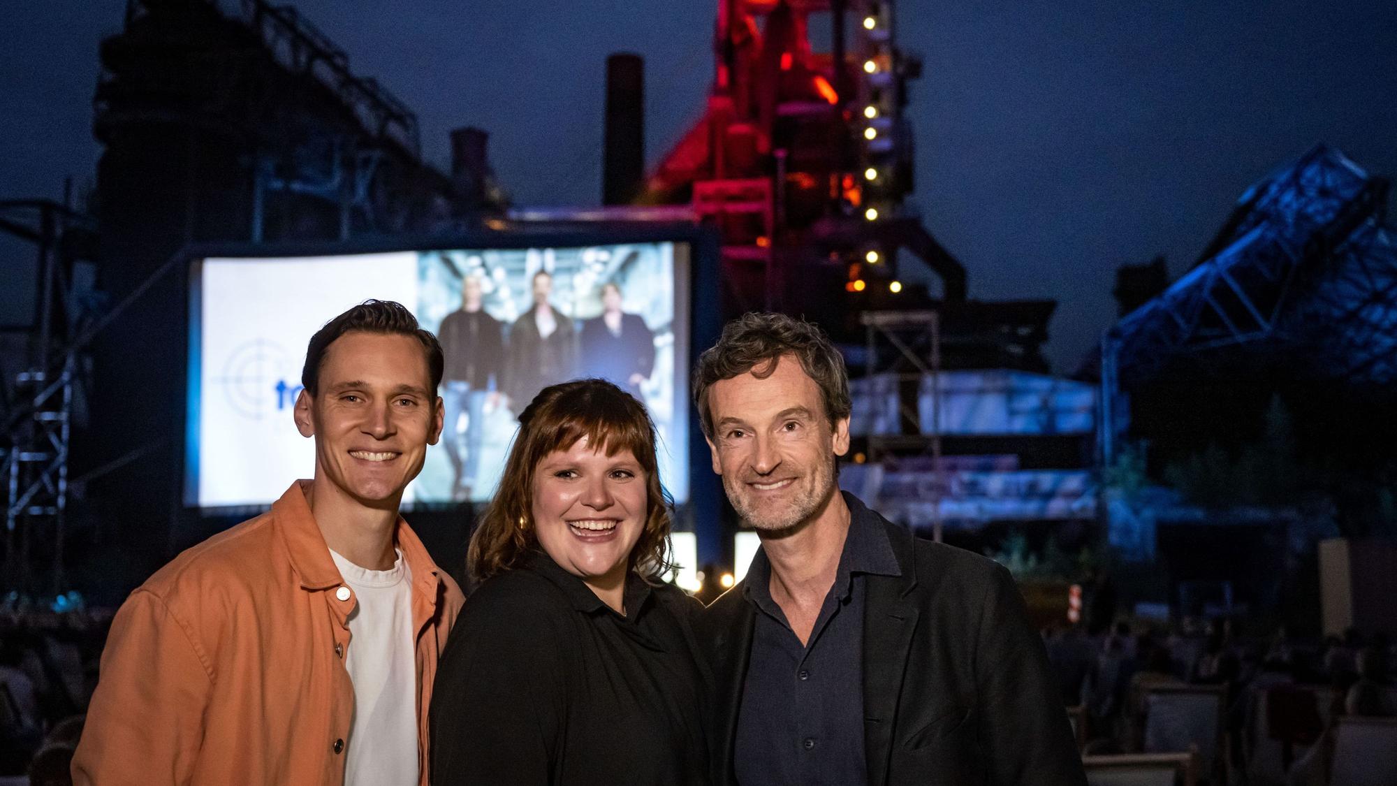 Die Hauptdarsteller des Tatorts aus Dortmund Jörg Hartmann (r, ·Kommissar Peter Farber·), Stefanie Reinsperger (·Rosa Herzog·) und Rick Okon (·Jan Pawlak·) stehen vor der Open-Air-Premiere für die neuste Folge ·Du bleibst hier· für ein Foto zusammen.