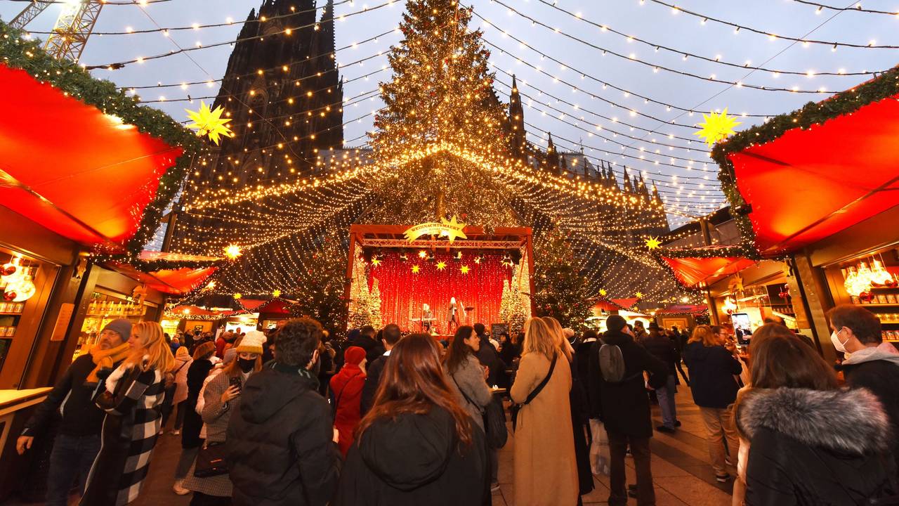 Auf dem Weihnachtsmarkt am Kölner Dom flanieren Besucherinnen und Besucher unter einem „Himmel“ aus Lichterketten.