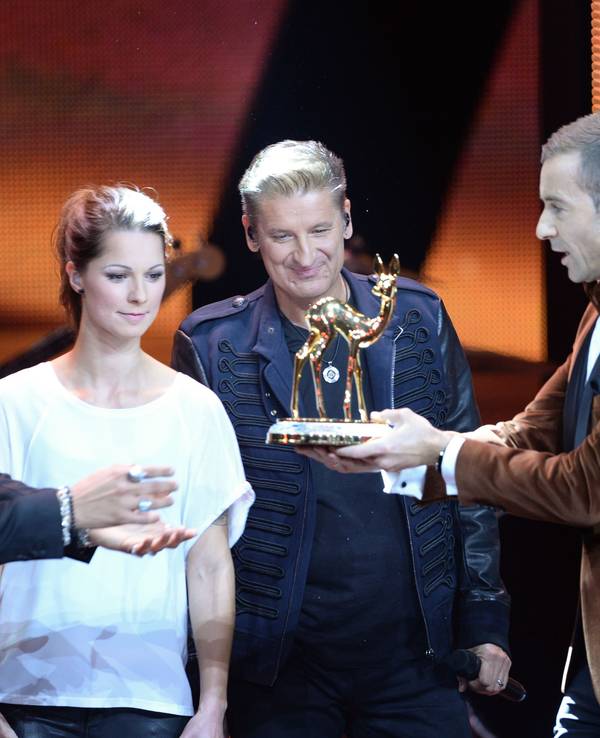 Moderator Kai Pflaume (r) zeichnet die Sänger Andreas Bourani (l-r), Christina Stürmer und Hartmut Engler stellvertretend für das Team von "Sing meinen Song" am 12.11.2015 in Berlin bei der 67. Bambi-Verleihung in der Kategorie "Musik national" aus.