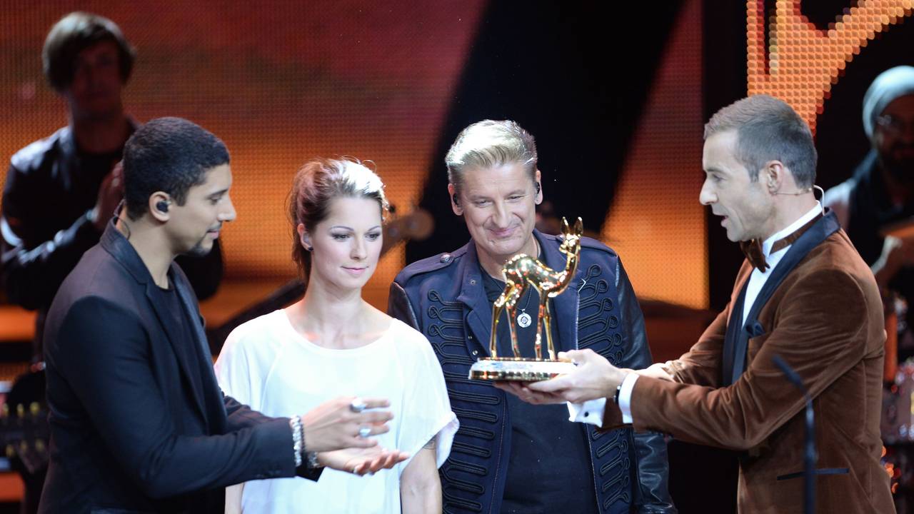 Moderator Kai Pflaume (r) zeichnet die Sänger Andreas Bourani (l-r), Christina Stürmer und Hartmut Engler stellvertretend für das Team von "Sing meinen Song" am 12.11.2015 in Berlin bei der 67. Bambi-Verleihung in der Kategorie "Musik national" aus.