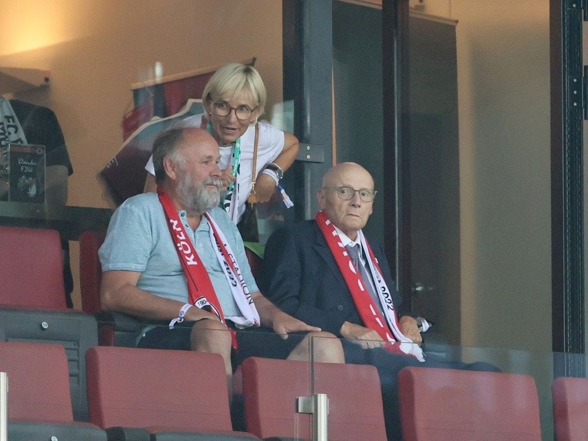 Franz-Josef Wernze (r.) sitzt beim Erstrundenspiel von Viktoria Köln gegen den FC Bayern München auf der Tribüne im Rhein-Energie-Stadion.