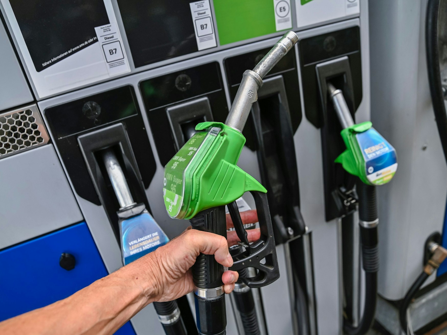 Eine Hand hält die Zapfpistole an einer Tankstelle. Mobilität wird für viele Menschen in Deutschland wieder deutlich teurer.
