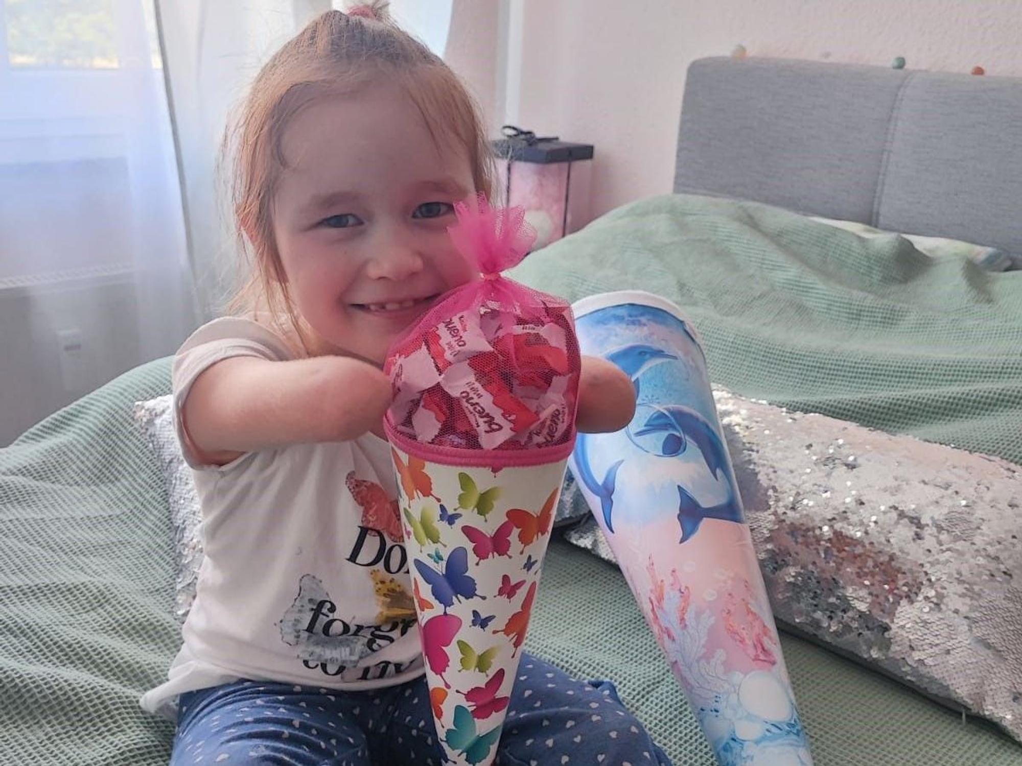 Ein Bild, das ans Herz geht: Milana hält glücklich und stolz ihre Schultüte zwischen den Ärmchen.