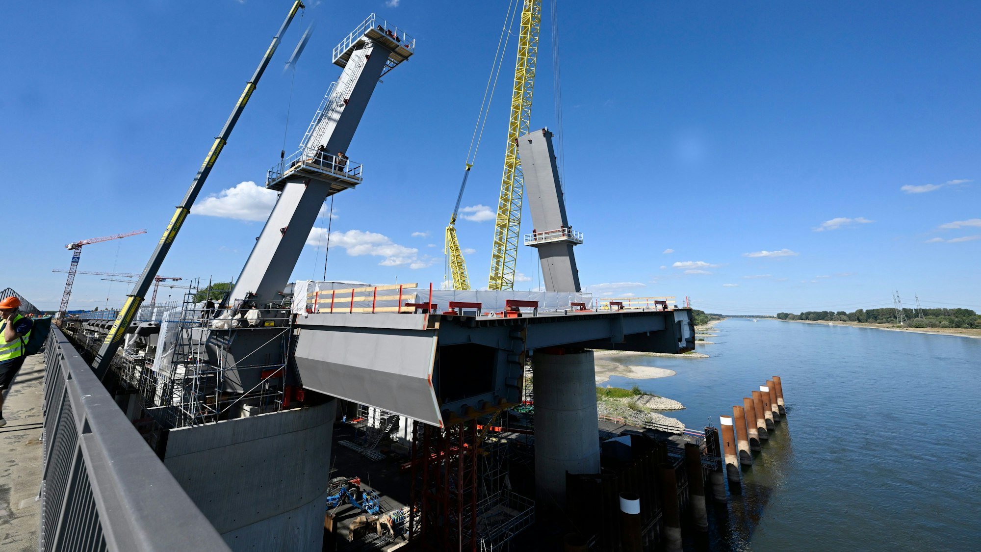 Blick auf den linksrheinischen Bauabschnitt des Neubaus der Autobahnbrücke in Leverkusen, wo am Donnerstag die Pylonen für das Seiltragwerk aufgestellt wurden. Das Seiltragwerk wird später die Konstruktion über dem Wasser sichern.