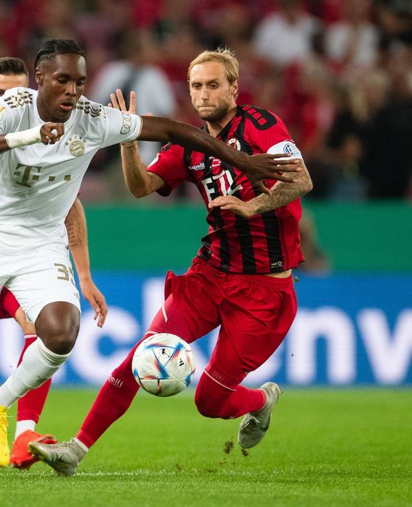 Kölns Marcel Risse (r) und Bayerns Mathys Tel kämpfen um den Ball.