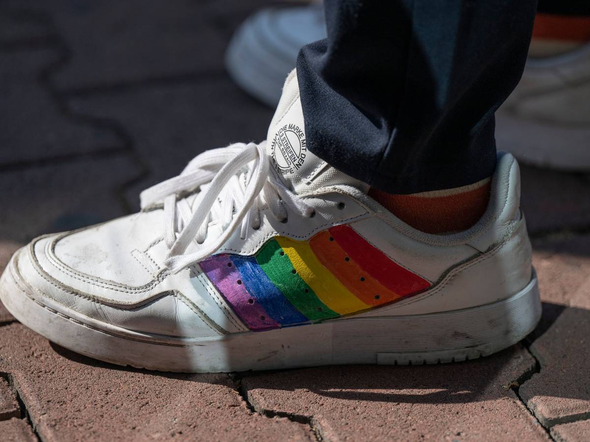 Das Foto von August 2022 zeigt einen weißen Sneaker, auf den die Regenbogenflagge als Erkennungszeichen der LGBTQI+-Community gemalt wurde.