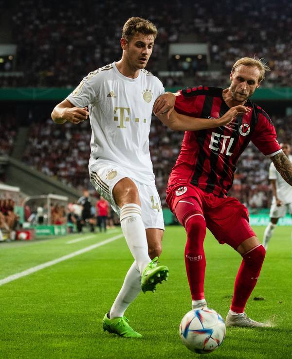 Bayerns Josip Stanisic (l) und Kölns Marcel Risse kämpfen um den Ball.