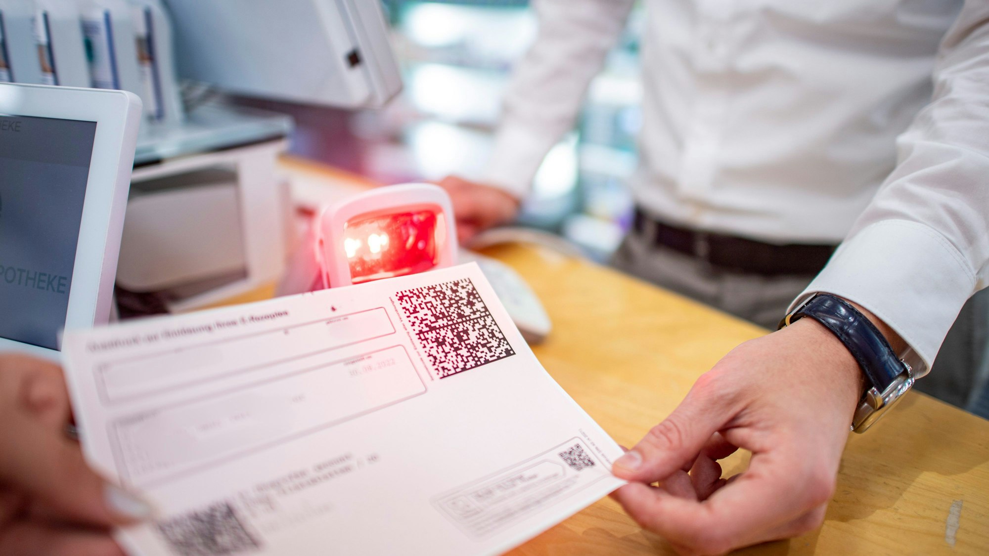 Inhaber Jan Harbecke scannt in seiner Jahreszeiten-Apotheke den QR-Code eines E-Rezepts ein.