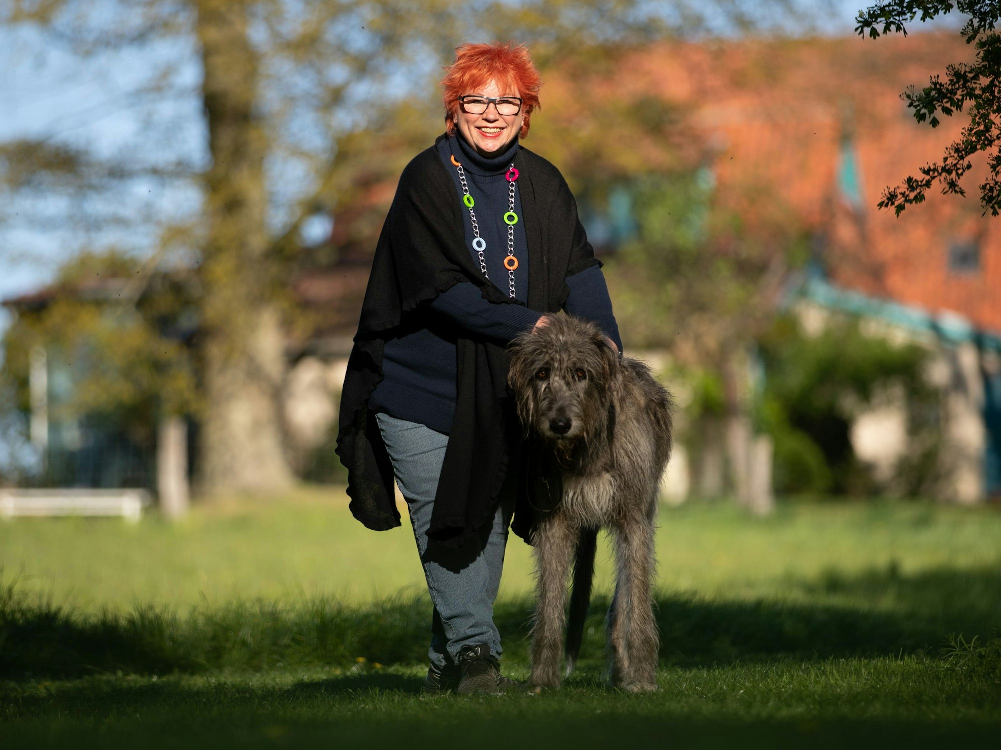 Barbara Salesch steht mit ihrem Hund Piri im Garten ihres Hauses.