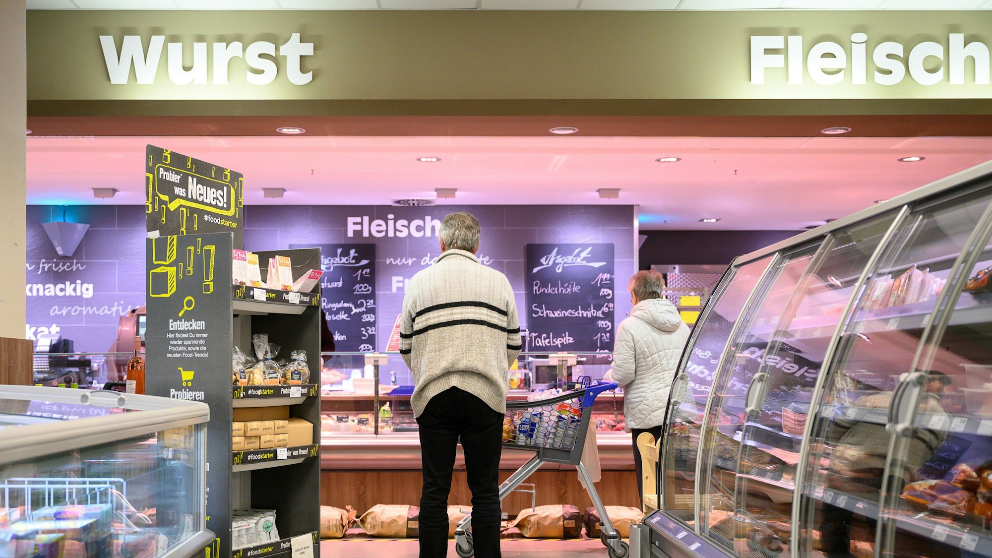 Ein beliebtes Fleisch-Produkt bei Edeka aus der Kühltheke wird aktuell zurückgerufen. Unser Symbolfoto zeigt Menschen beim Einkauf in einem Edeka.
